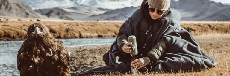 Femme qui se fait du café en camping dans les montagnes